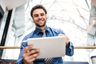 businessman with tablet and headphones in office businessman_with_tablet_and_headphones_in_office