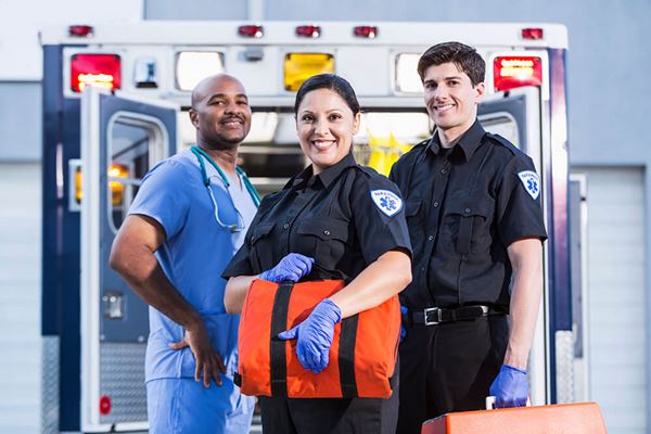 EMTs paramedics smiling at back of ambulance EMTs paramedics smiling at back of ambulance