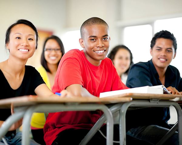 high school students sitting at desks in classroom 2 high school students sitting at desks in classroom